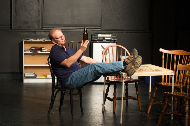 Peter Nerad, as The Player in "Boys in the Basement" contemplates a fine bottle of beer.